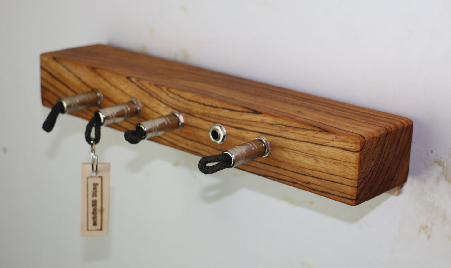 Schlüsselboard aus Holz mit Klinkenstecker.
Der Klinkenstecker kommt einfach an den Ring des Schlüssels. Mit einem „click“ steckt er im Board und kann so beim Gehen auch wieder herausgezogen werden.
So einfach kann Ordnung sein!
Und weil es Spaß macht, macht ihr es auch (ja, auch die Person, von der ihr gerade denkt: „Never, der nicht!“).
Nie wieder den Schlüssel suchen.