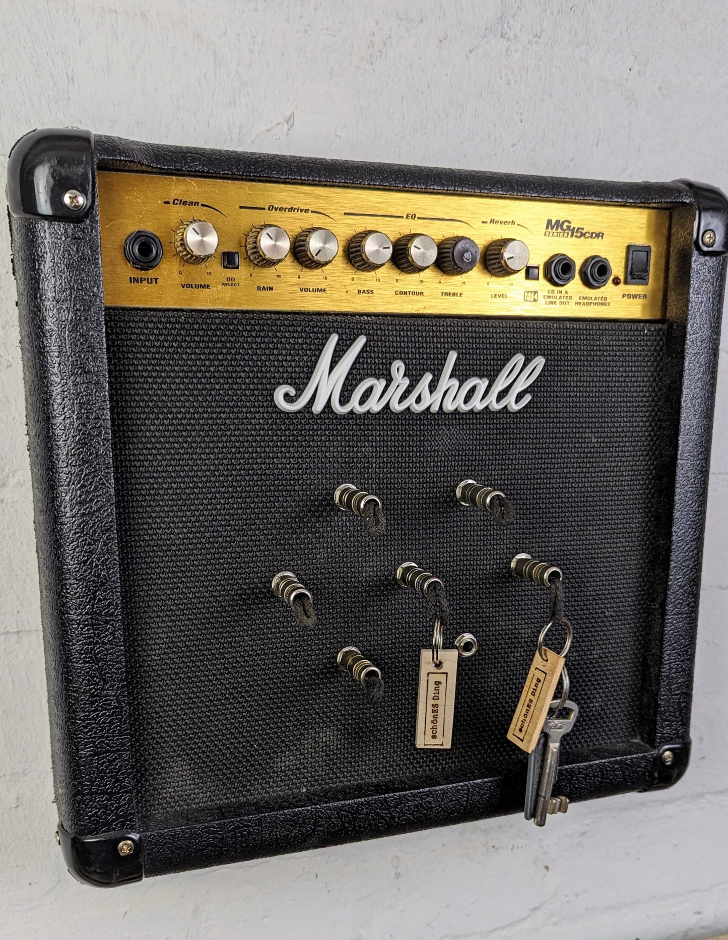 Schlüsselboard aus einem original Marschall Verstärker mit Klinkenstecker.
Der Klinkenstecker kommt einfach an den Ring des Schlüssels. Mit einem „click“ steckt er im Board und kann so beim Gehen auch wieder herausgezogen werden.
So einfach kann Ordnung sein!
Und weil es Spaß macht, macht ihr es auch (ja, auch die Person, von der ihr gerade denkt: „Never, der nicht!“).
Nie wieder den Schlüssel suchen.
www.schönesding.de