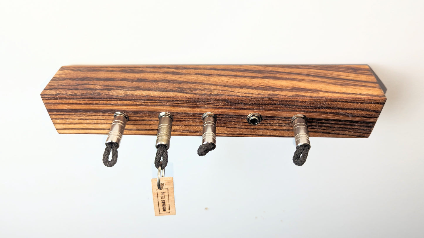Schlüsselboard aus Holz mit Klinkenstecker.
Der Klinkenstecker kommt einfach an den Ring des Schlüssels. Mit einem „click“ steckt er im Board und kann so beim Gehen auch wieder herausgezogen werden.
So einfach kann Ordnung sein!
Und weil es Spaß macht, macht ihr es auch (ja, auch die Person, von der ihr gerade denkt: „Never, der nicht!“).
Nie wieder den Schlüssel suchen.
www.schönesding.de