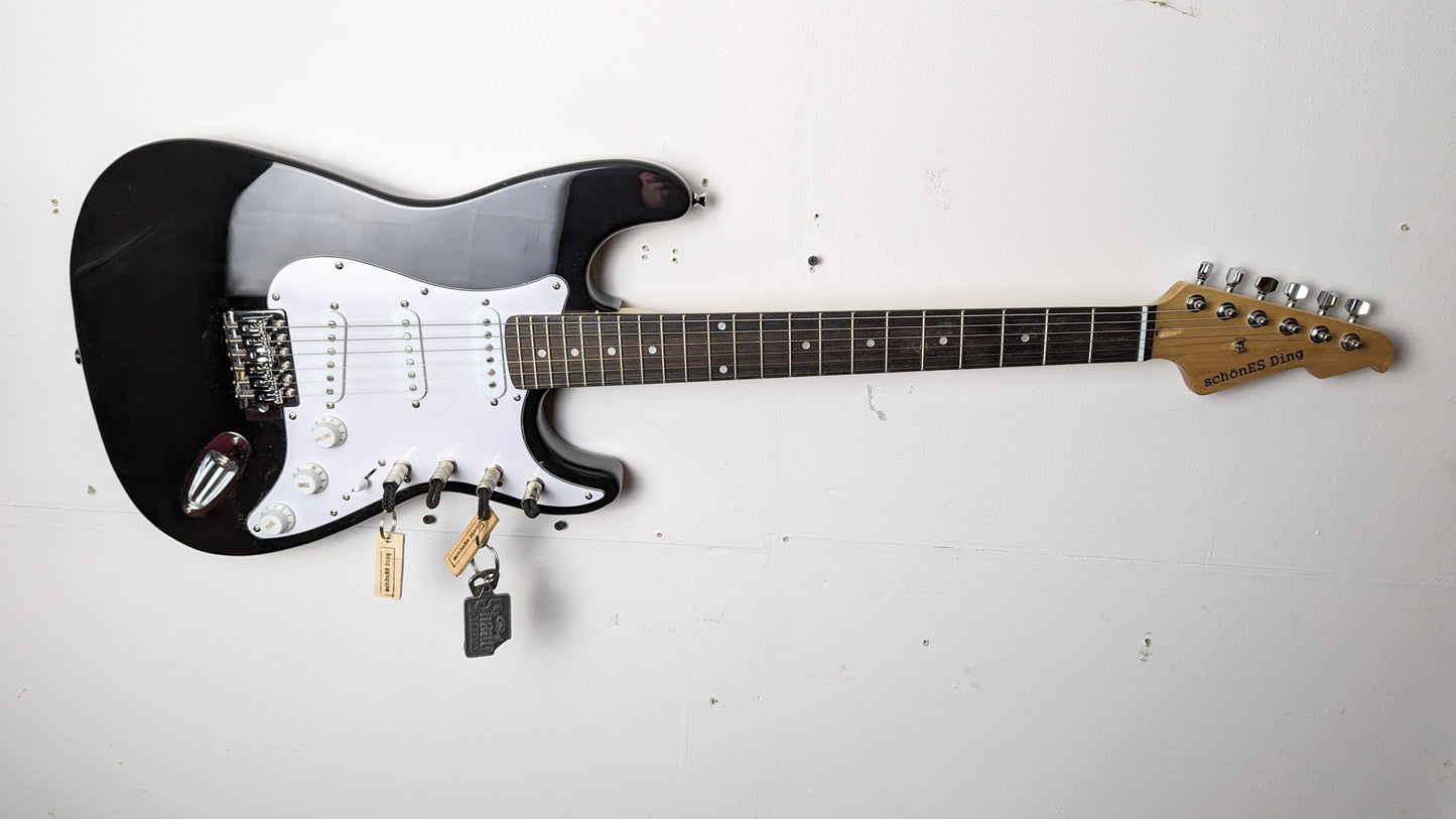 Schlüsselboard aus E-Gitarre mit Klinkenstecker.
Der Klinkenstecker kommt einfach an den Ring des Schlüssels. Mit einem „click“ steckt er im Board und kann so beim Gehen auch wieder herausgezogen werden.
So einfach kann Ordnung sein!
Und weil es Spaß macht, macht ihr es auch (ja, auch die Person, von der ihr gerade denkt: „Never, der nicht!“).
Nie wieder den Schlüssel suchen.