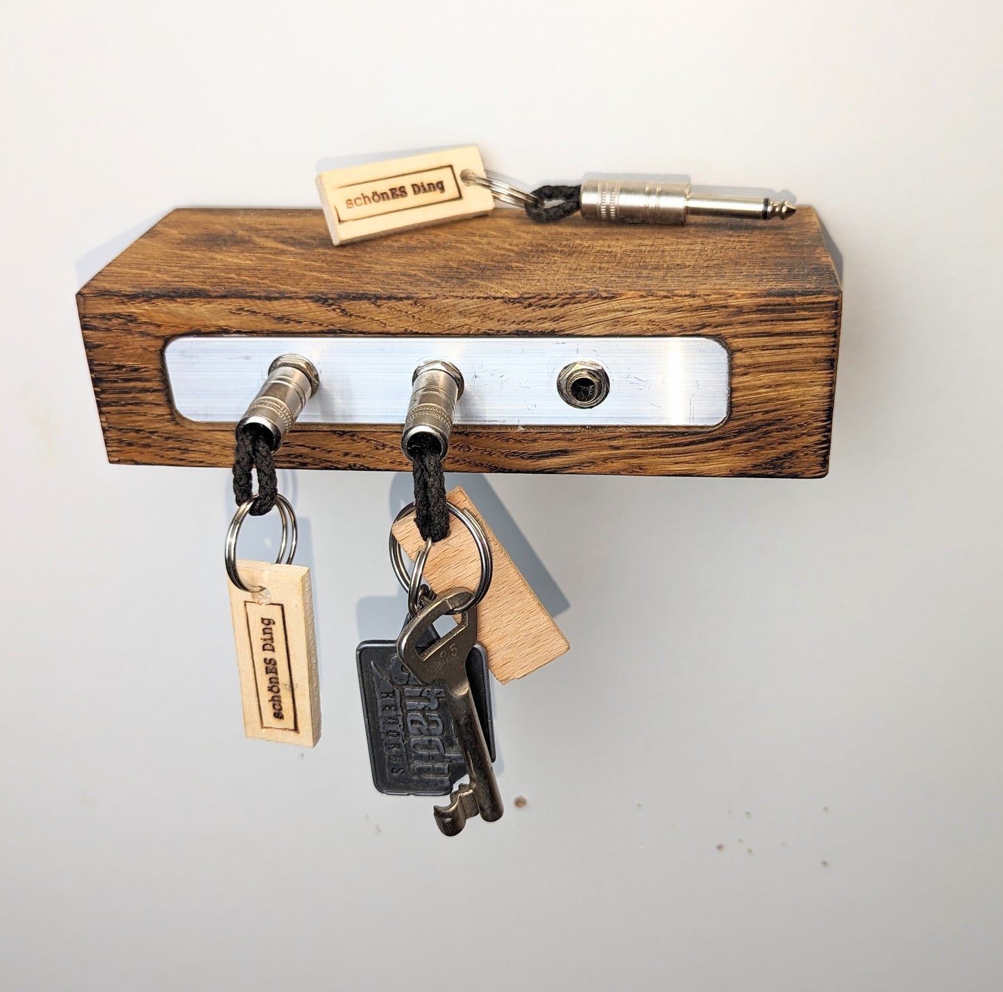 Schlüsselboard aus Holz mit Klinkenstecker.
Der Klinkenstecker kommt einfach an den Ring des Schlüssels. Mit einem „click“ steckt er im Board und kann so beim Gehen auch wieder herausgezogen werden.
So einfach kann Ordnung sein!
Und weil es Spaß macht, macht ihr es auch (ja, auch die Person, von der ihr gerade denkt: „Never, der nicht!“).
Nie wieder den Schlüssel suchen.