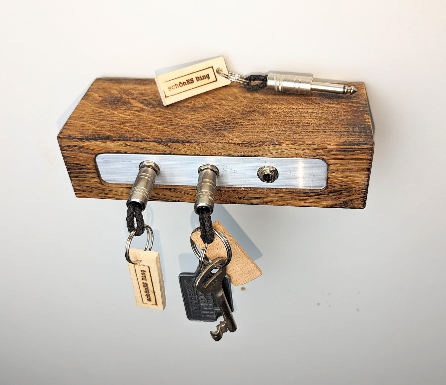 Schlüsselboard aus Holz mit Klinkenstecker.
Der Klinkenstecker kommt einfach an den Ring des Schlüssels. Mit einem „click“ steckt er im Board und kann so beim Gehen auch wieder herausgezogen werden.
So einfach kann Ordnung sein!
Und weil es Spaß macht, macht ihr es auch (ja, auch die Person, von der ihr gerade denkt: „Never, der nicht!“).
Nie wieder den Schlüssel suchen.