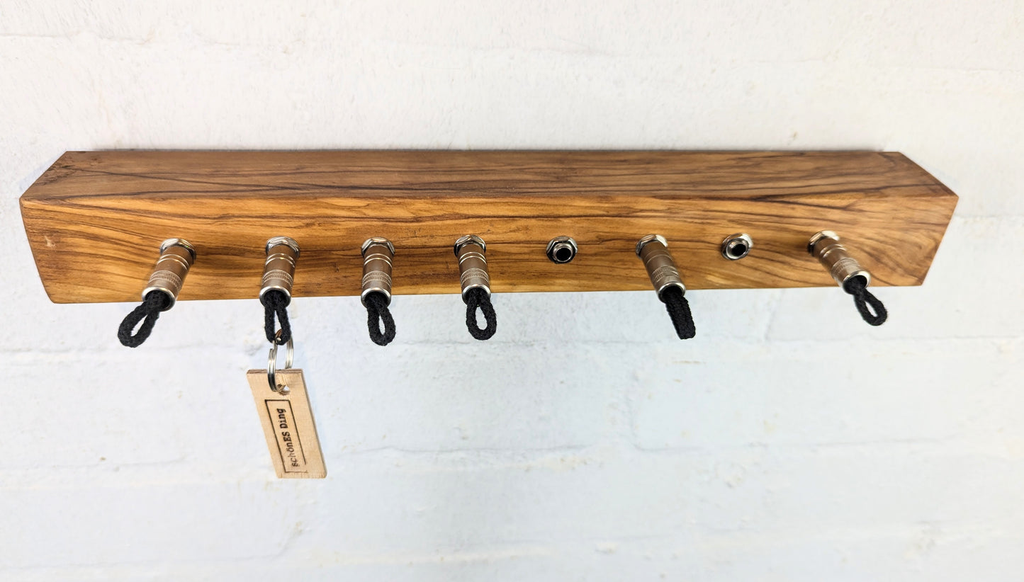 Schlüsselboard aus Olivenholz mit Klinkenstecker.
Der Klinkenstecker kommt einfach an den Ring des Schlüssels. Mit einem „click“ steckt er im Board und kann so beim Gehen auch wieder herausgezogen werden.
So einfach kann Ordnung sein!
Und weil es Spaß macht, macht ihr es auch (ja, auch die Person, von der ihr gerade denkt: „Never, der nicht!“).
Nie wieder den Schlüssel suchen.
www.schönesding.de