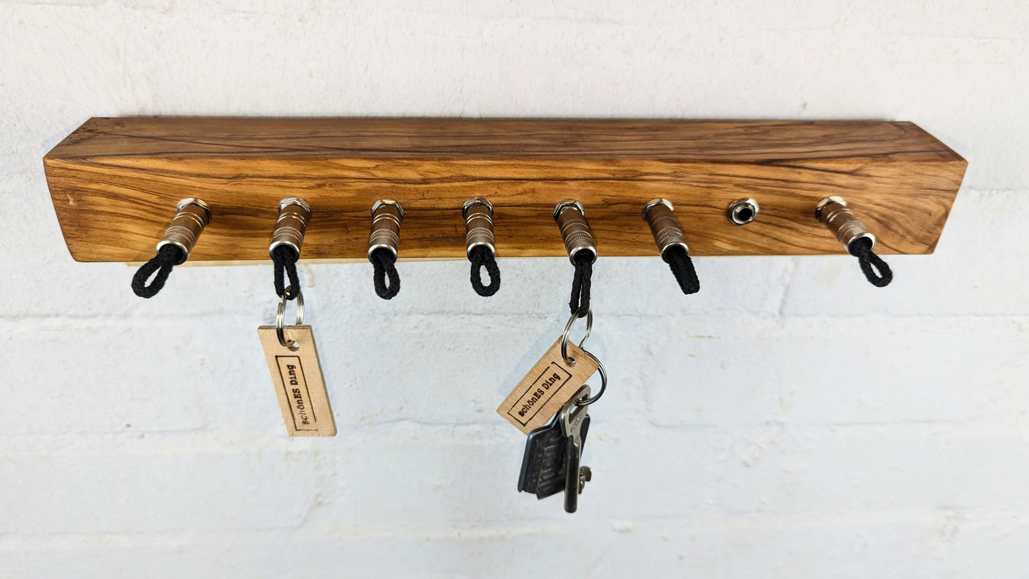 Schlüsselboard aus Olivenholz mit Klinkenstecker.
Der Klinkenstecker kommt einfach an den Ring des Schlüssels. Mit einem „click“ steckt er im Board und kann so beim Gehen auch wieder herausgezogen werden.
So einfach kann Ordnung sein!
Und weil es Spaß macht, macht ihr es auch (ja, auch die Person, von der ihr gerade denkt: „Never, der nicht!“).
Nie wieder den Schlüssel suchen.
www.schönesding.de