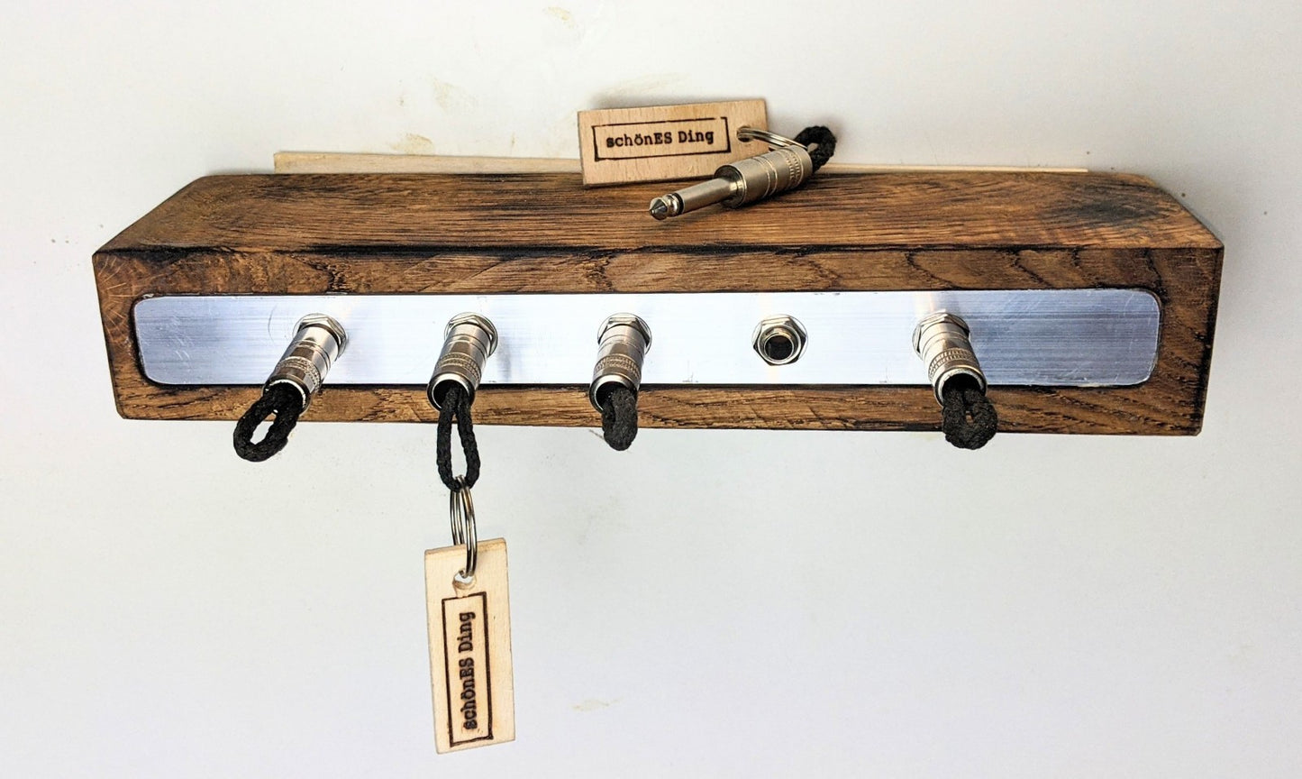 Schlüsselboard aus Holz mit Klinkenstecker.
Der Klinkenstecker kommt einfach an den Ring des Schlüssels. Mit einem „click“ steckt er im Board und kann so beim Gehen auch wieder herausgezogen werden.
So einfach kann Ordnung sein!
Und weil es Spaß macht, macht ihr es auch (ja, auch die Person, von der ihr gerade denkt: „Never, der nicht!“).
Nie wieder den Schlüssel suchen.
