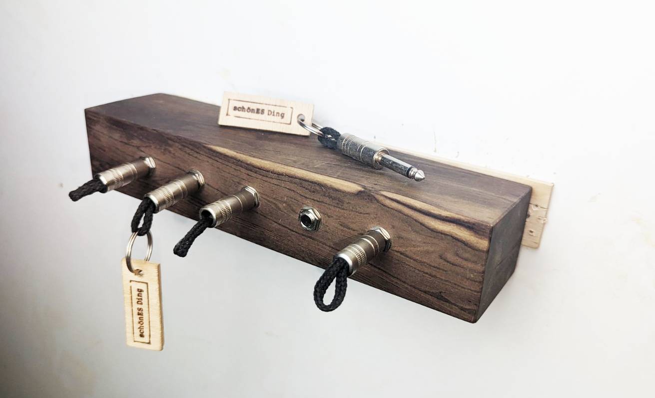 Schlüsselboard aus Holz mit Klinkenstecker.
Der Klinkenstecker kommt einfach an den Ring des Schlüssels. Mit einem „click“ steckt er im Board und kann so beim Gehen auch wieder herausgezogen werden.
So einfach kann Ordnung sein!
Und weil es Spaß macht, macht ihr es auch (ja, auch die Person, von der ihr gerade denkt: „Never, der nicht!“).
Nie wieder den Schlüssel suchen.