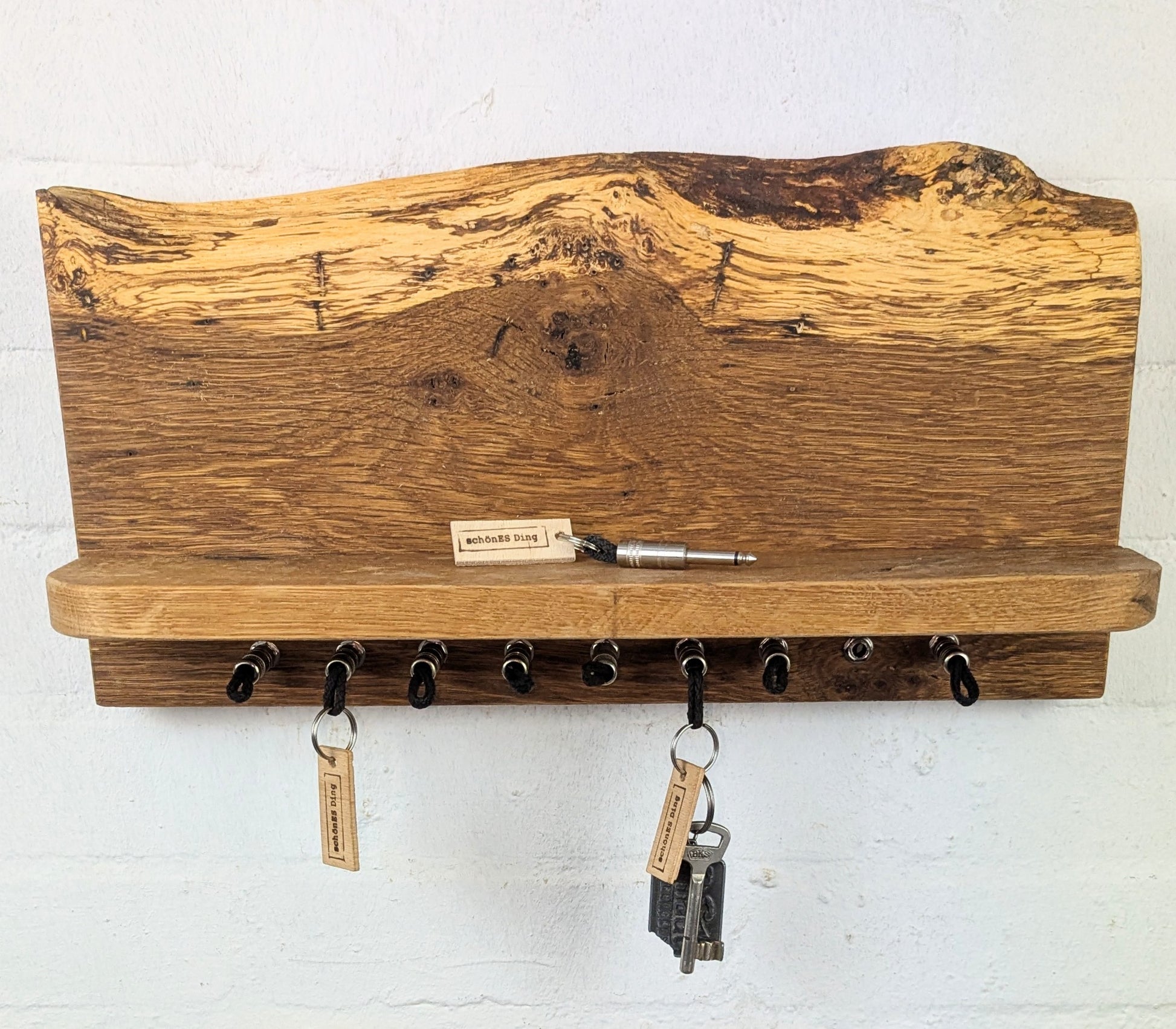 Das "Board-Board" aus Eichenbohle mit Naturkante, schöner Maserung und 9cm Ablage.

Das Board hat 9 Steckplätzen.

Auf der Rückseite befindet die die Wandaufhängung.

Mit dabei natürlich die Schlüsselanhänger.