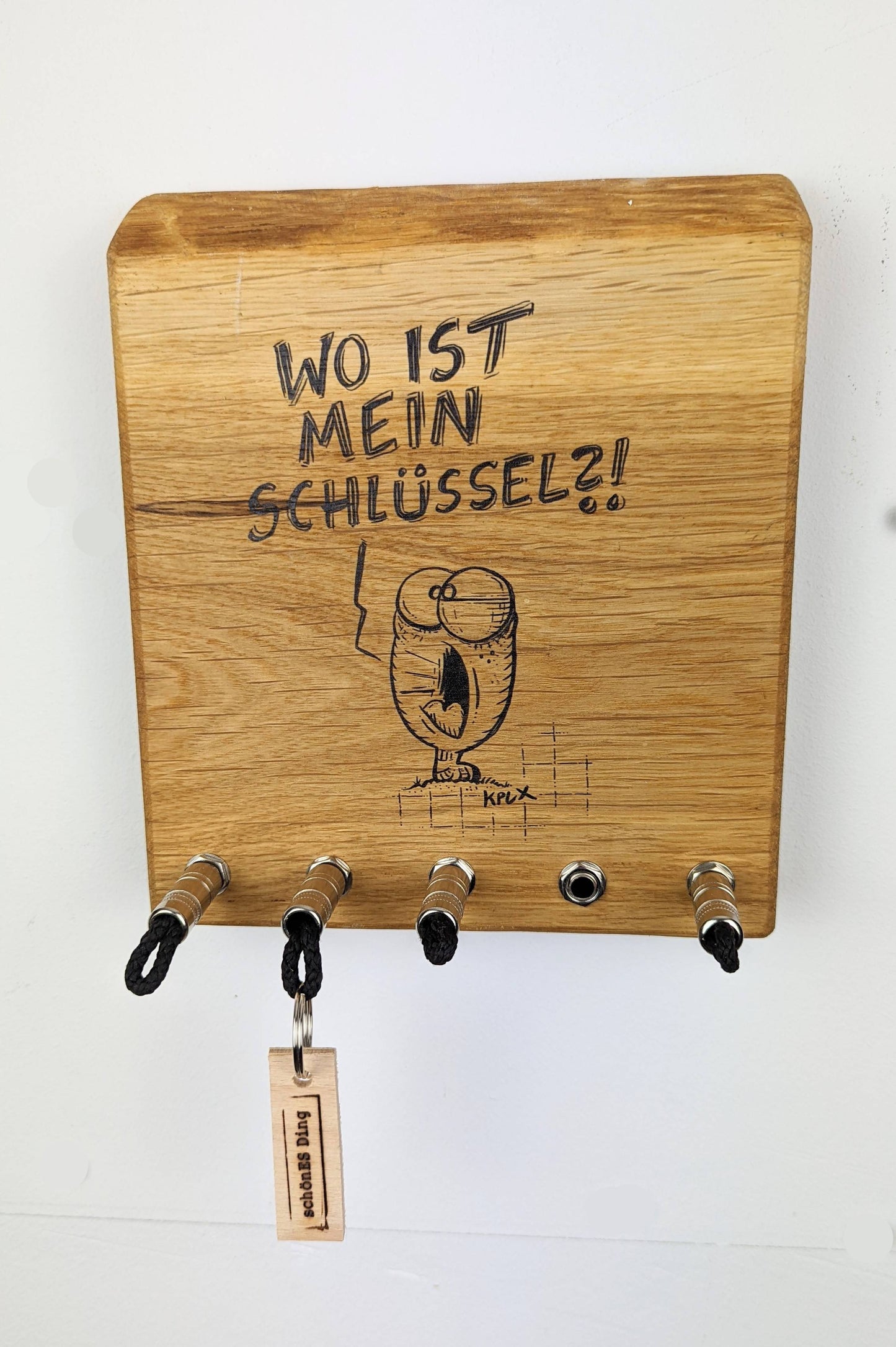 Schlüsselboard aus Holz mit Klinkenstecker.
Mit einem Motiv von KPLX  (https://www.kplx.art/)
Der Klinkenstecker kommt einfach an den Ring des Schlüssels. Mit einem „click“ steckt er im Board und kann so beim Gehen auch wieder herausgezogen werden.
So einfach kann Ordnung sein!
Und weil es Spaß macht, macht ihr es auch (ja, auch die Person, von der ihr gerade denkt: „Never, der nicht!“).
Nie wieder den Schlüssel suchen.
www.schönesding.de
