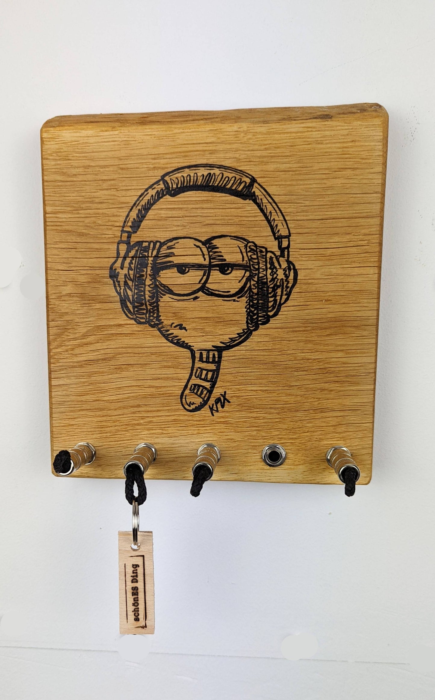 Schlüsselboard aus Holz mit Klinkenstecker.
Mit einem Motiv von KPLX  (https://www.kplx.art/)
Der Klinkenstecker kommt einfach an den Ring des Schlüssels. Mit einem „click“ steckt er im Board und kann so beim Gehen auch wieder herausgezogen werden.
So einfach kann Ordnung sein!
Und weil es Spaß macht, macht ihr es auch (ja, auch die Person, von der ihr gerade denkt: „Never, der nicht!“).
Nie wieder den Schlüssel suchen.
www.schönesding.de
