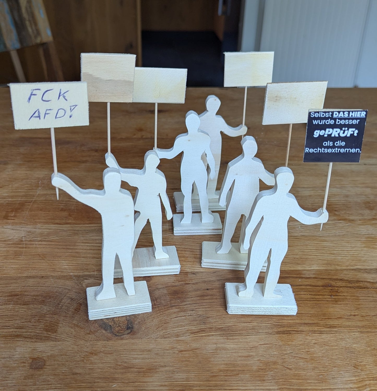 Demonstranten aus Holz. Plakate zum selbst gestalten