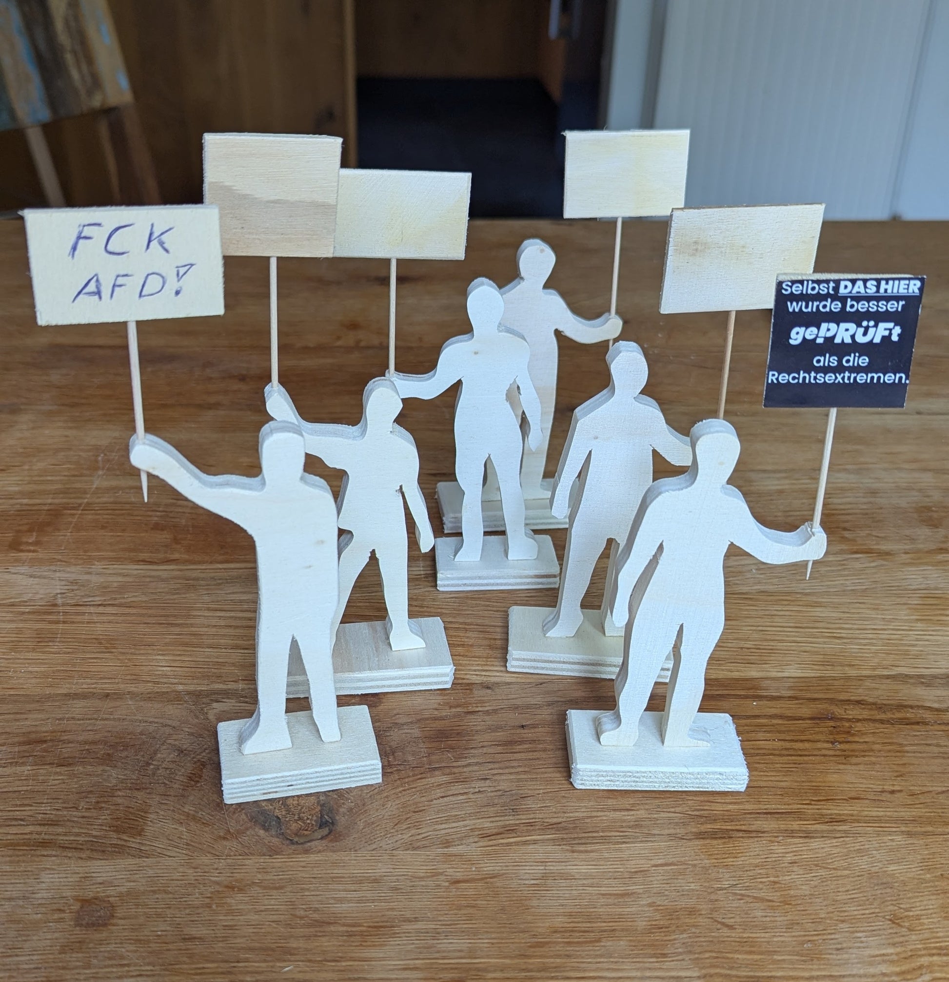 Demonstranten aus Holz. Plakate zum selbst gestalten