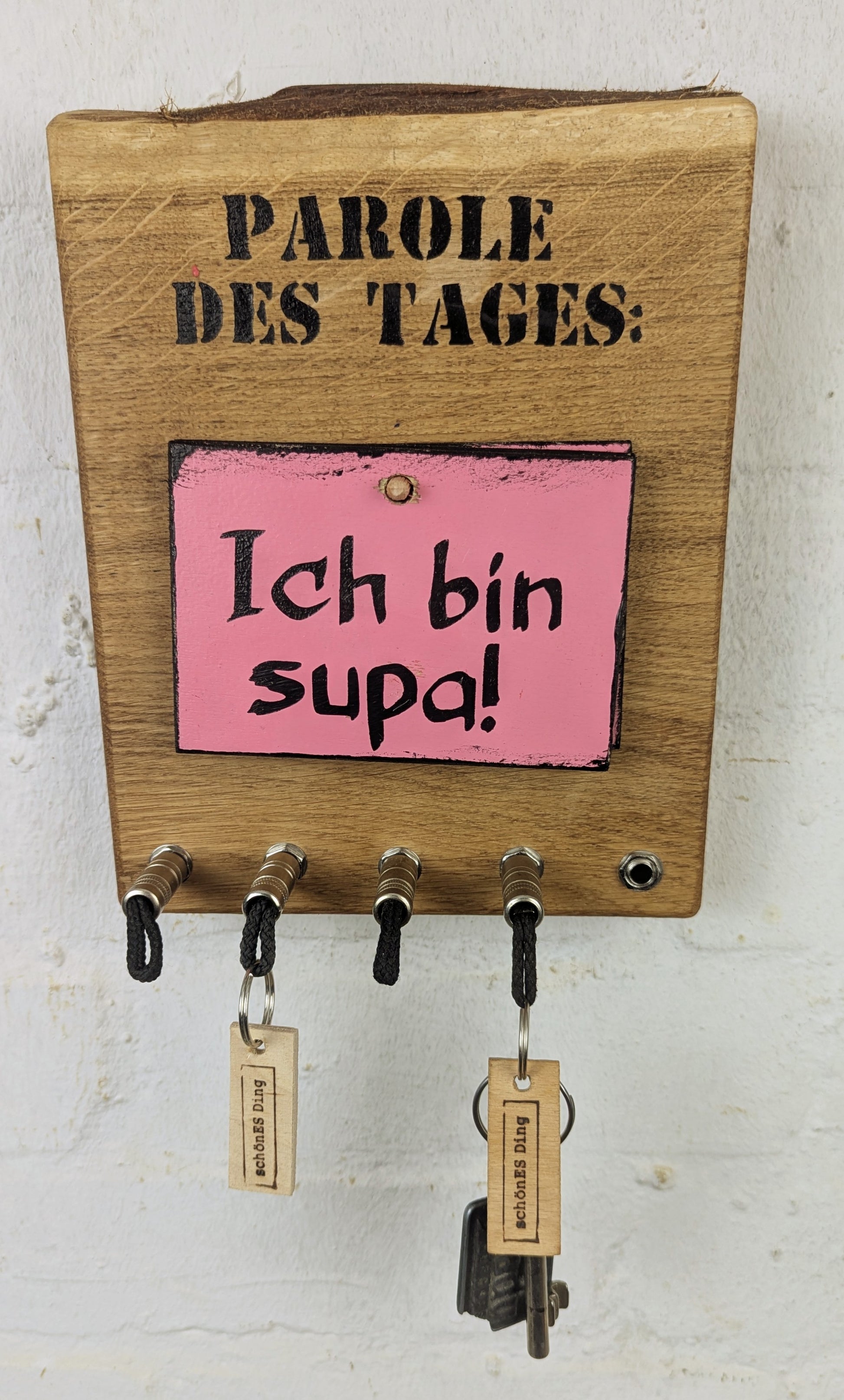 Geschliffen und geölte 3cm dicke Eichenbohle mit Naturkante.
Dazu gibt es drei Tafeln mit 6 Stimmungen, die dich durch den Tag bringen.

Wie es geht:
Der Klinkenstecker kommt einfach an den Ring des Schlüssels. Mit einem „click“ steckt er im Board und kann so beim Gehen auch wieder herausgezogen werden.
So einfach kann Ordnung sein!

Und weil es Spaß macht, macht ihr es auch (ja, auch die Person, von der ihr gerade denkt: „Never, der nicht!“).

Nie wieder den Schlüssel suchen.