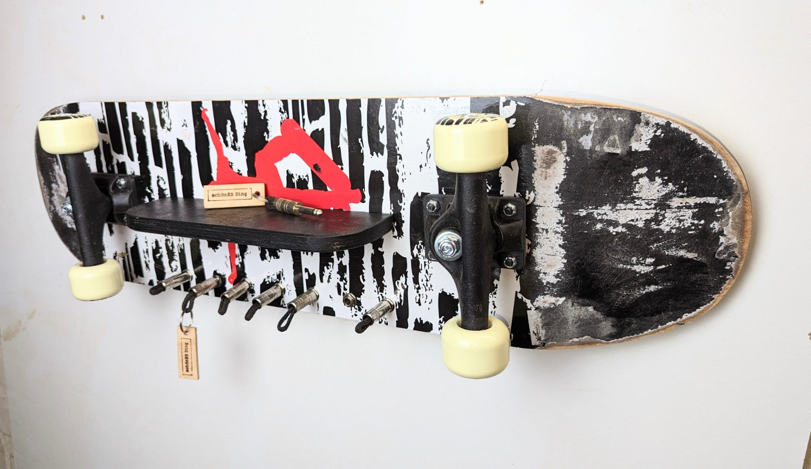 Schlüsselboard aus einem Skateboard mit Klinkenstecker.
Der Klinkenstecker kommt einfach an den Ring des Schlüssels. Mit einem „click“ steckt er im Board und kann so beim Gehen auch wieder herausgezogen werden.
So einfach kann Ordnung sein!
Und weil es Spaß macht, macht ihr es auch (ja, auch die Person, von der ihr gerade denkt: „Never, der nicht!“).
Nie wieder den Schlüssel suchen.
www.schönesding.de
