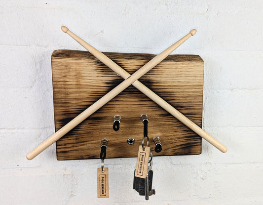 Das Schlüsselboard mit gekreuzten Drumsticks, leicht geflammt mit Naturkante.

35cm breit mit fünf Steckplätzen.

Die Schlüsselanhänger sind natürlich dabei.

Aufhängung auf der Rückseite.