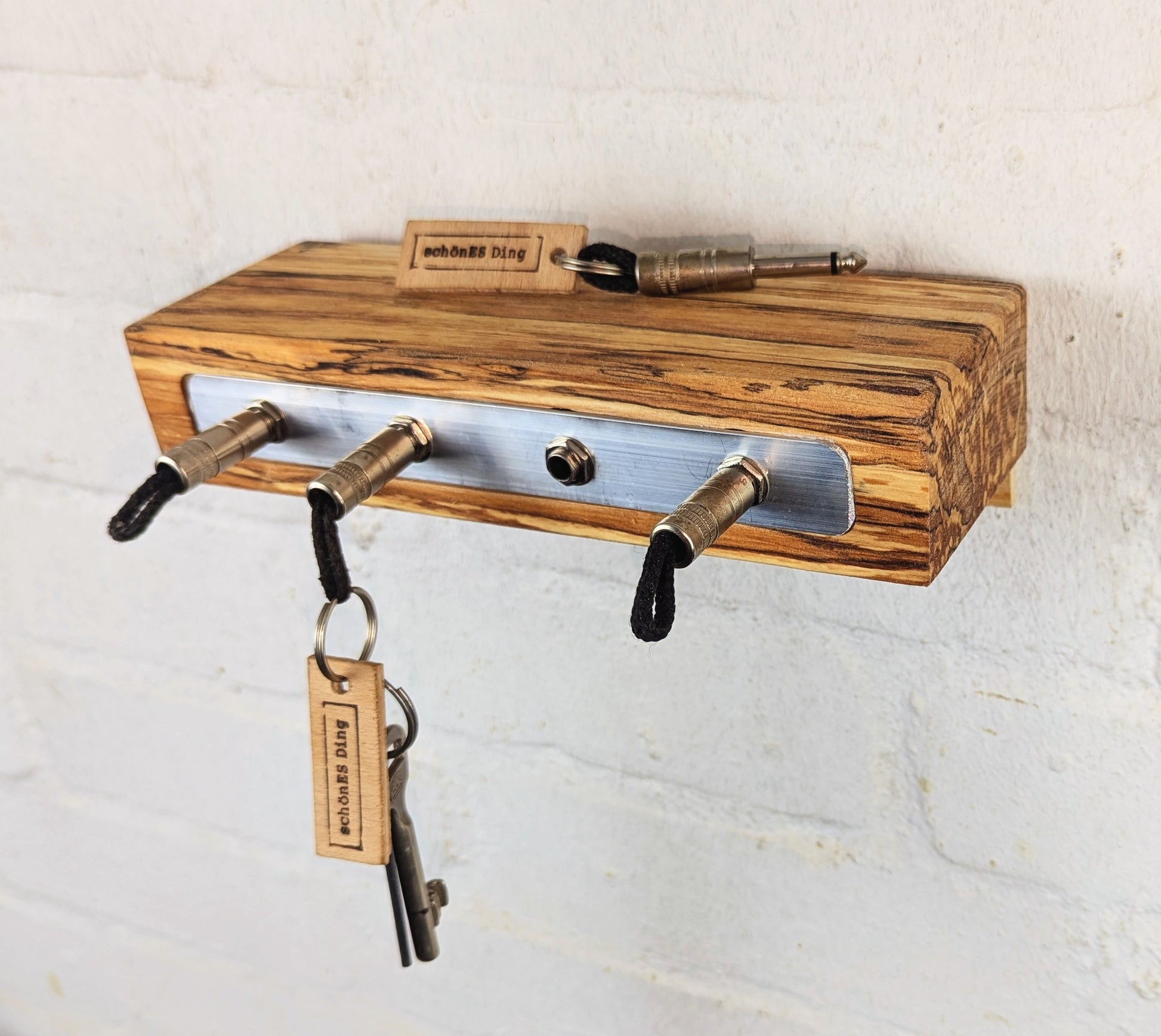 Schlüsselboard aus fünf Zentimeter dicker, gestockter Buchenbohle.
Geschliffen und geölt, mit einmaligem Farbverlauf. Das ist das Ergebnis.
Die Steckerleiste ist eingearbeitet.
Durch die Tiefe von 9cm dient das Board gleichzeitig als Ablagefläche.