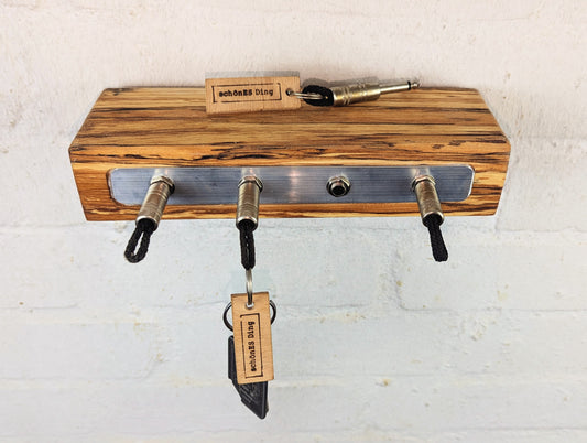 Schlüsselboard aus fünf Zentimeter dicker, gestockter Buchenbohle.
Geschliffen und geölt, mit einmaligem Farbverlauf. Das ist das Ergebnis.
Die Steckerleiste ist eingearbeitet.
Durch die Tiefe von 9cm dient das Board gleichzeitig als Ablagefläche.